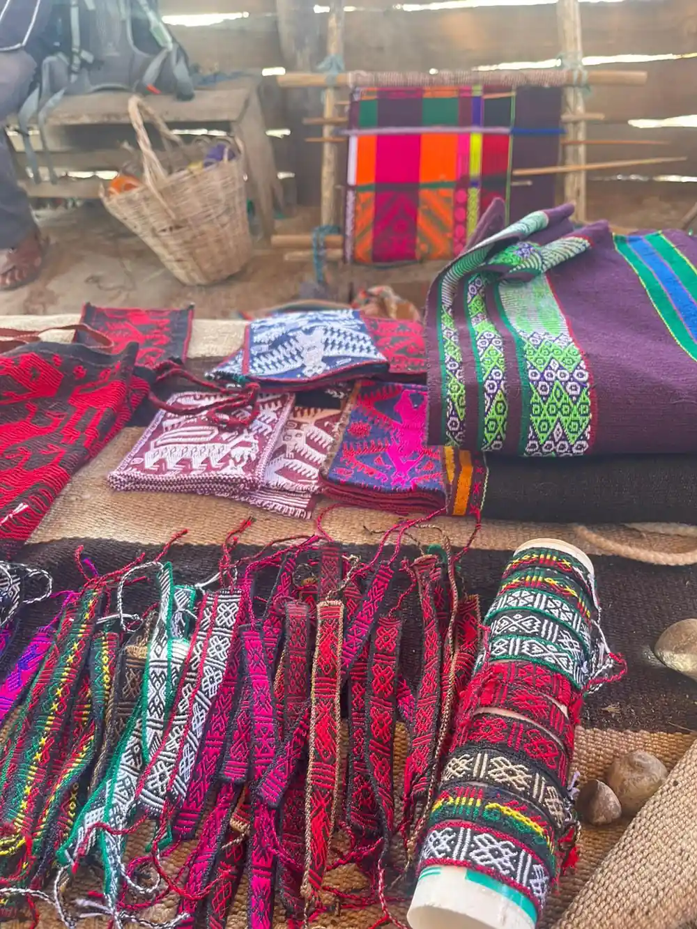 Woven textiles in bright colours laid out on a table